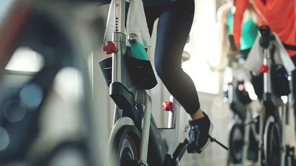 Ein Mädchen, das im Fitnessstudio mit einem Heimtrainer läuft, um ihre Oberschenkel zu trainieren. 