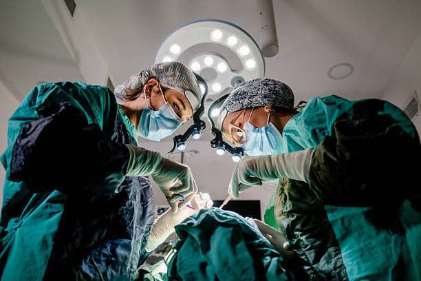 Surgeons performing plastic surgery in Albania operating room.