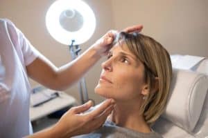 Woman receiving a cosmetic consultation in a medical clinic in Albania.